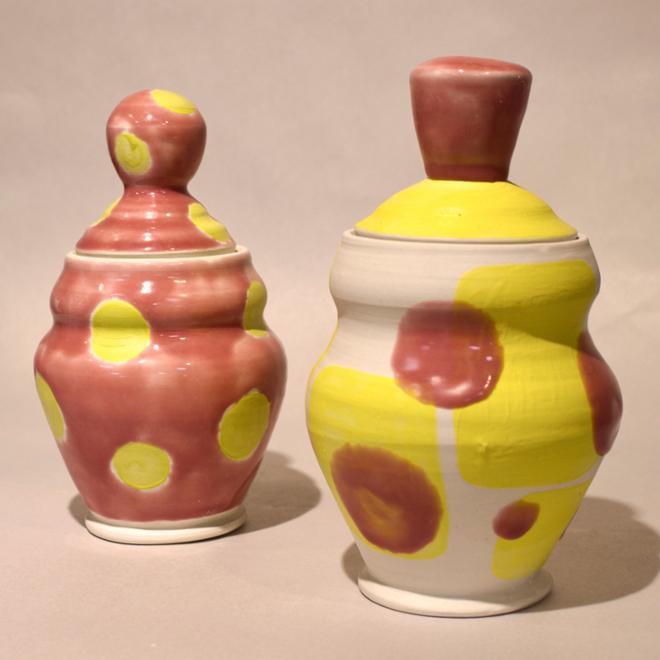 Two lidded jars, pink and yellow polka dot glazed.