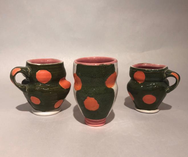 Three mugs with red spots and green and white stripes. 