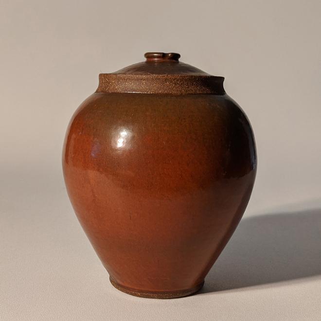 Red/brown glazed ceramic lidded jar.