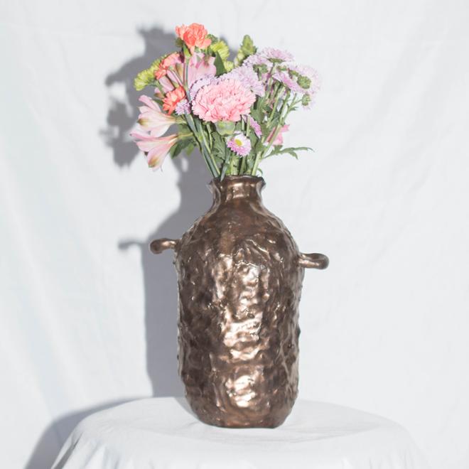 Bronzed ceramic vase with handles, with bouquet of flowers.