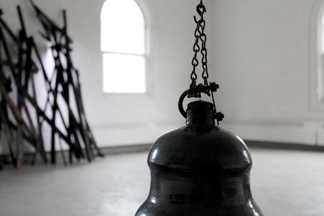 Close up of black vessel hung by chains.