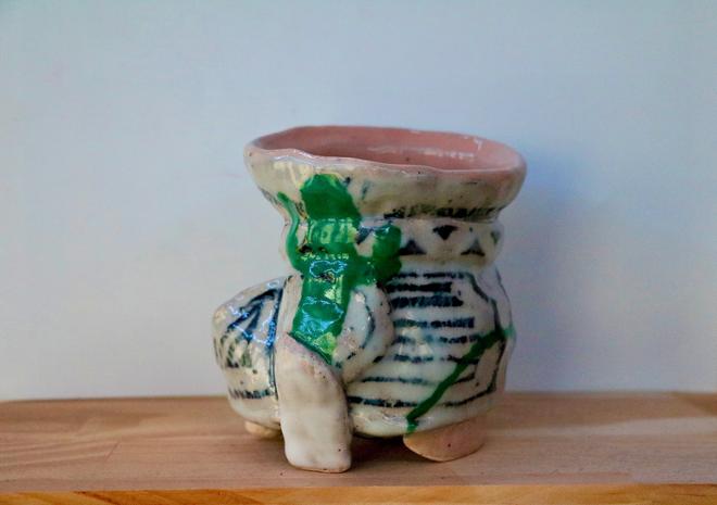 Small ceramic cup with legs.