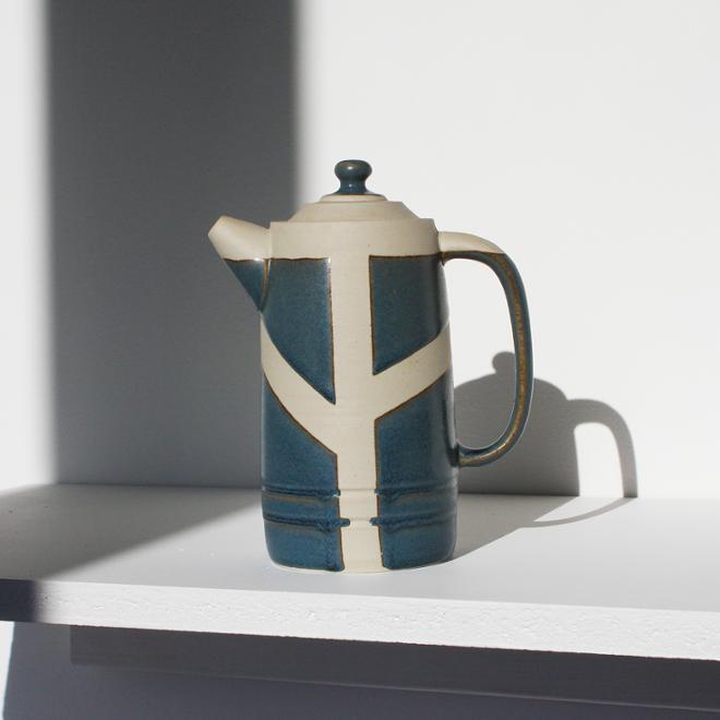 A tall teapot with blue and white glaze detailing