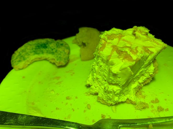 A green tinted image of a slice of cake on a plate. 