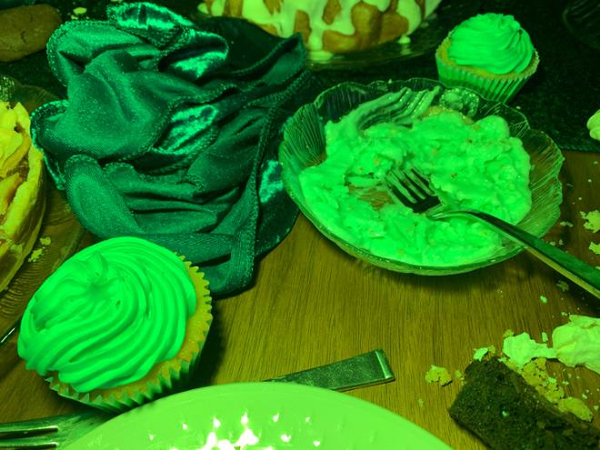 A green tinted image of an assortment of food on a table. 
