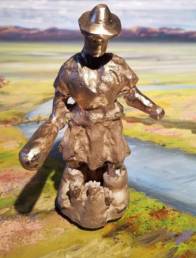 A bronze figure holding a bat. 
