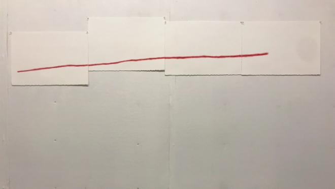 A red line going across paper. 