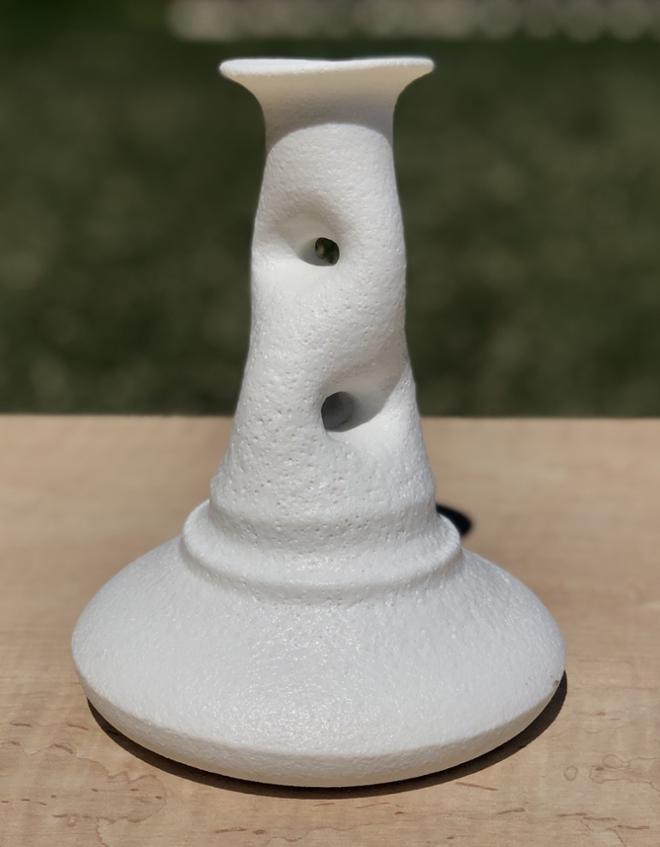 A white ceramic piece with holes in it. 