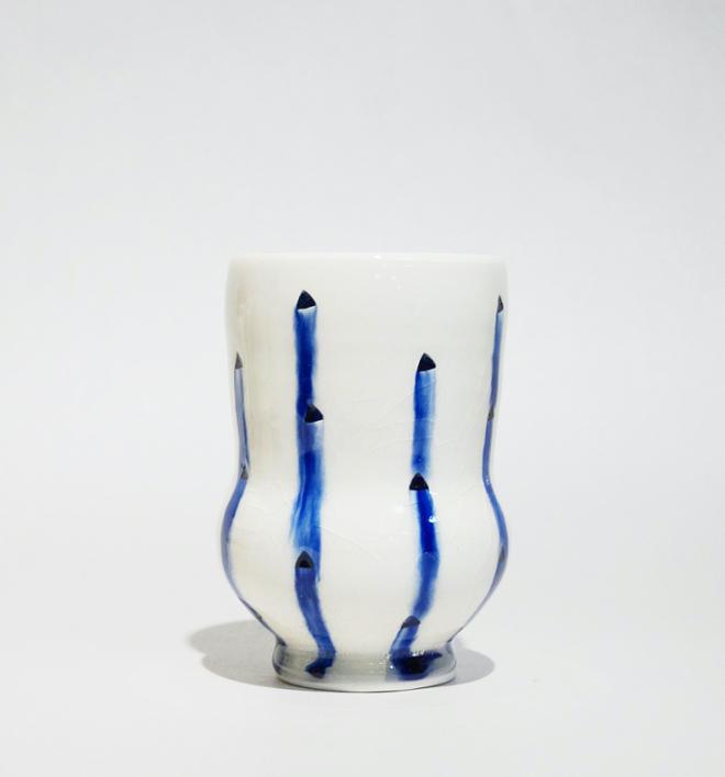 A white ceramic cup with blue vertical stripes. 