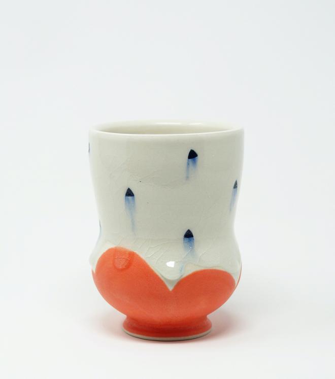 A white ceramic cup with blue dots