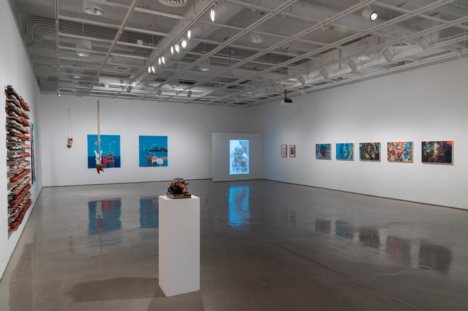 diverse collection of art pieces on three walls of the gallery