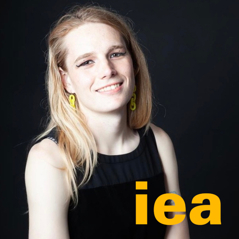 Headshot of Artist Lorelei d'Andriole with IEA logo in bottom right corner